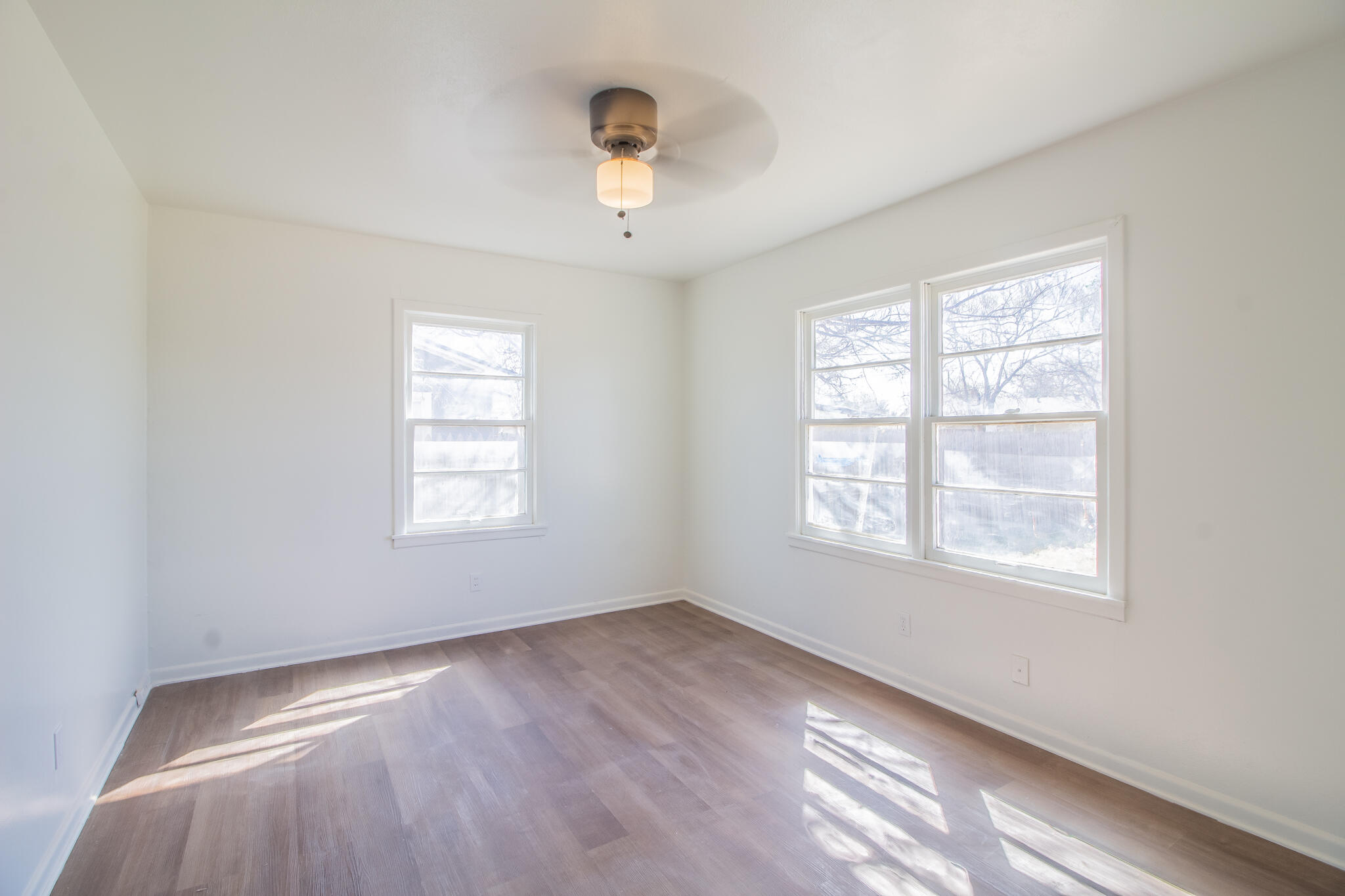 4621 35th Street Lubbock, TX 79414 - Photo 12 of 19 a view of an empty room with wooden floor and a window