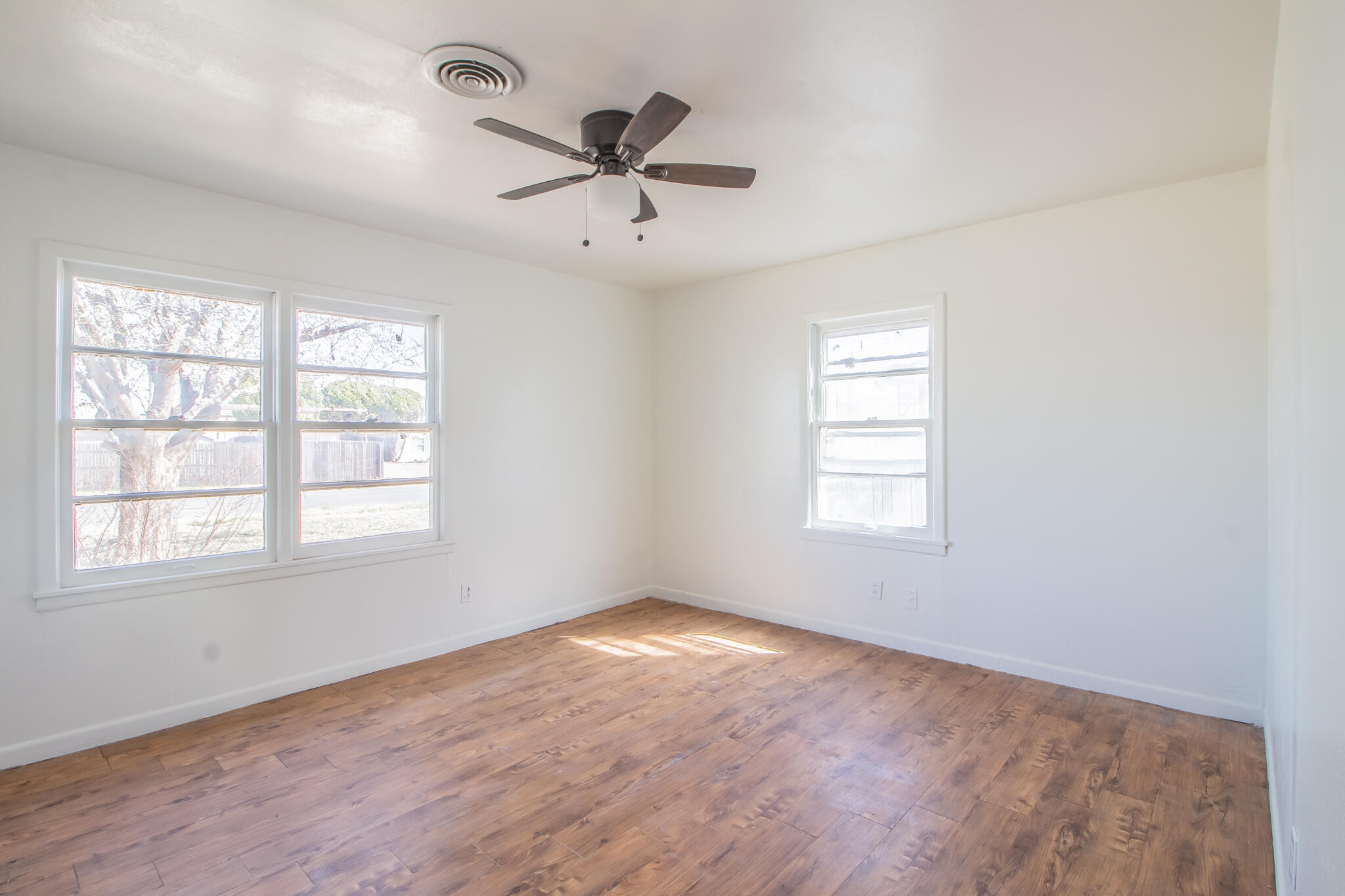 4621 35th Street Lubbock, TX 79414 - Photo 13 of 19 a view of empty room with wooden floor and fan