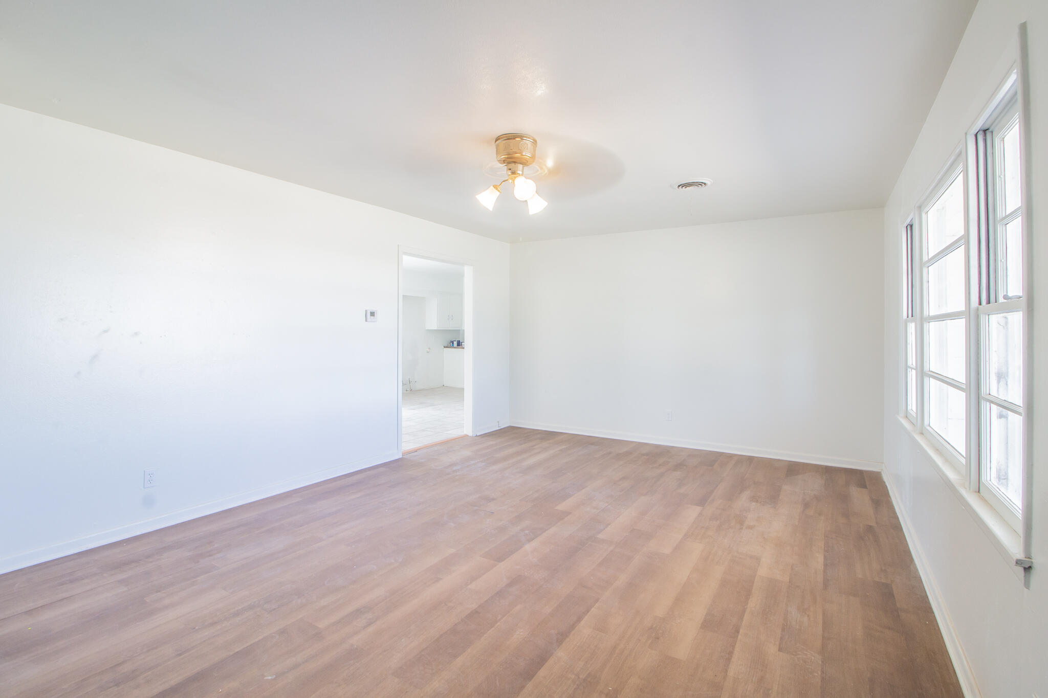 4621 35th Street Lubbock, TX 79414 - Photo 4 of 19 wooden floor in an empty room with a window