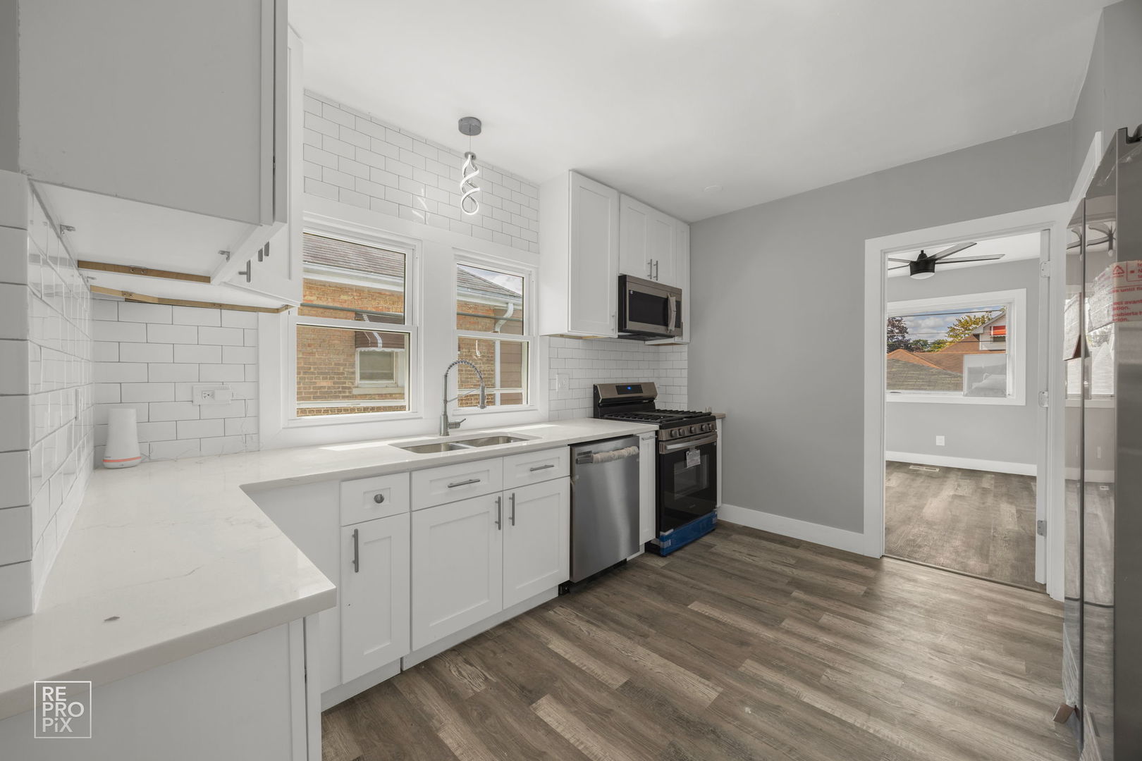 628 South 19th Avenue Maywood, IL 60153 - Photo 4 of 10 a kitchen with granite countertop a stove top oven a sink dishwasher and a refrigerator with wooden floor