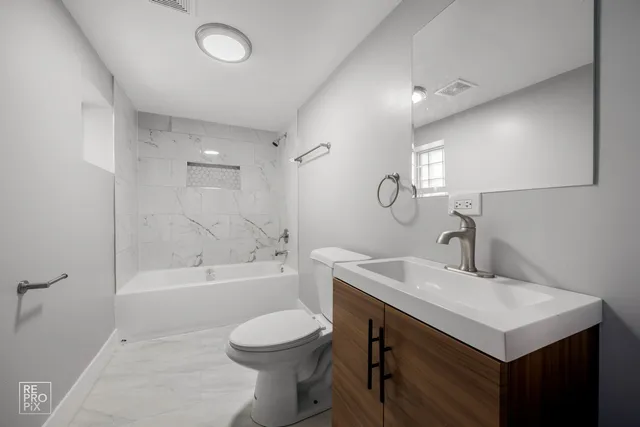 a bathroom with a sink toilet vanity and shower