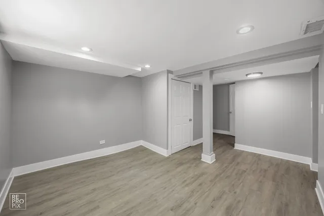 a view of an empty room with wooden floor