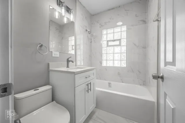 a bathroom with a granite countertop toilet a sink and a bathtub