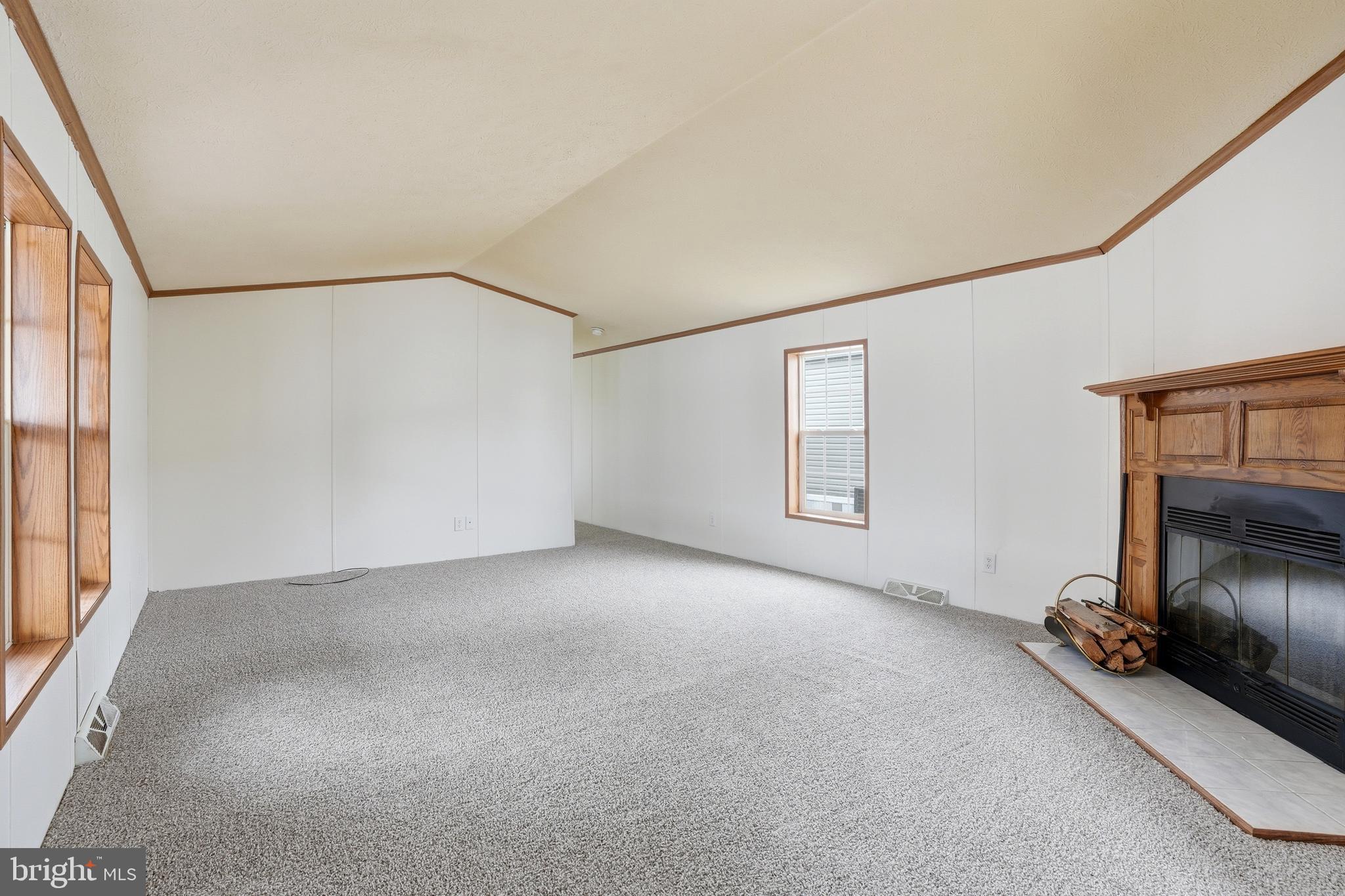 507 Canter Road Wilmington, DE 19810 - Photo 8 of 15 a view of an empty room with a fireplace and a window