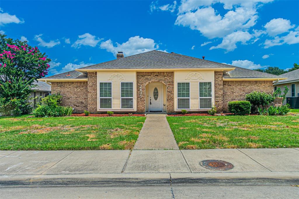 a view of a brick house with a yard
