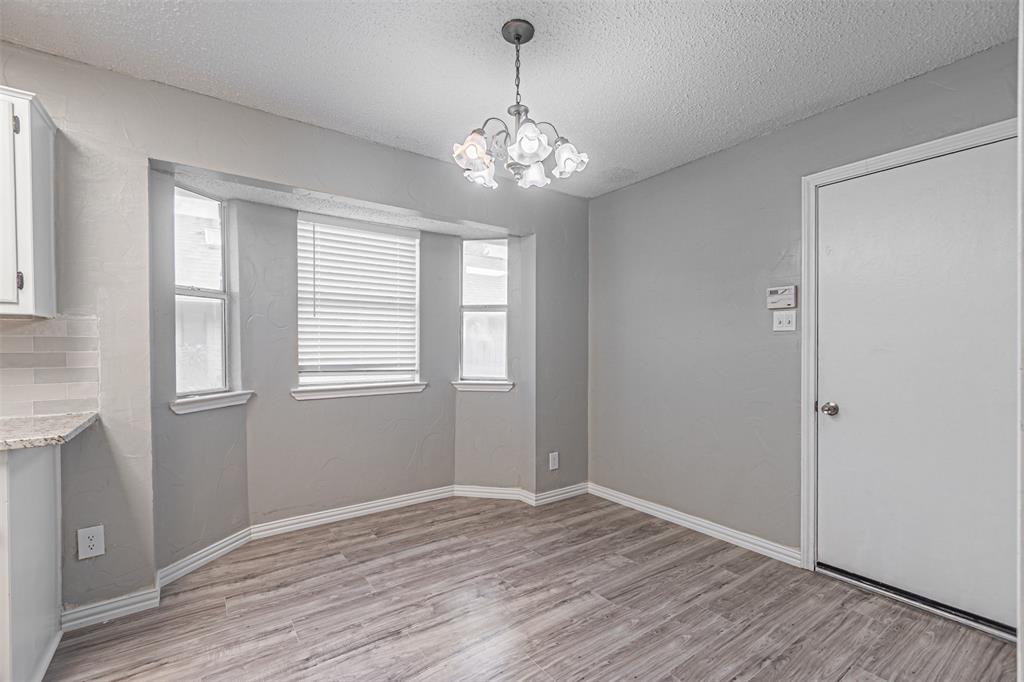 2435 Old Mill Road Dallas, TX 75287 - Photo 13 of 30 a view of an empty room with wooden floor and windows