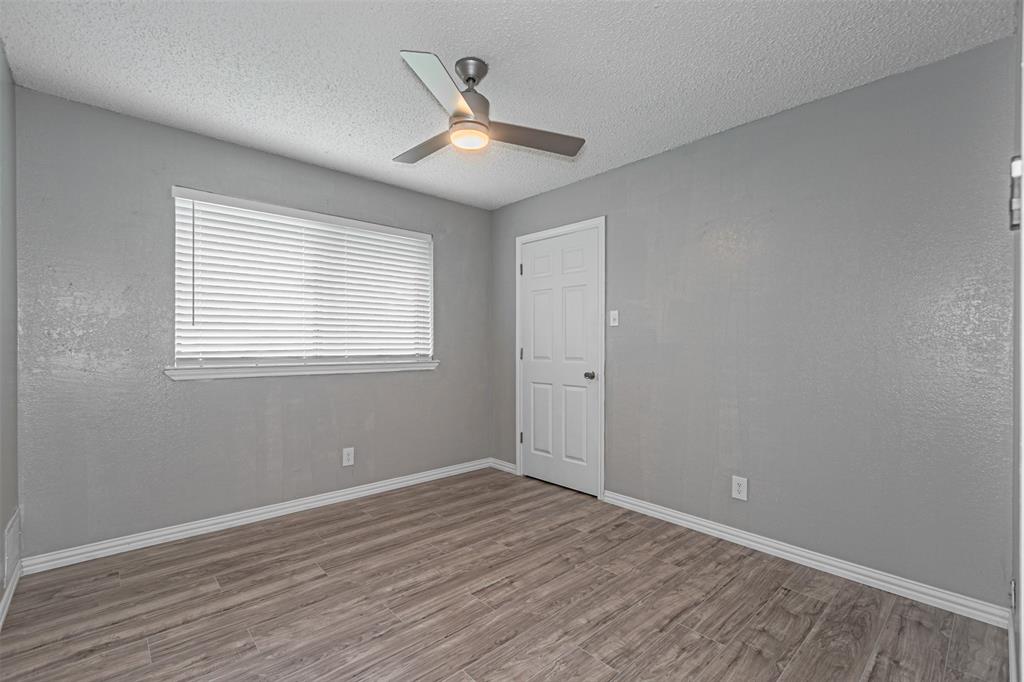 2435 Old Mill Road Dallas, TX 75287 - Photo 23 of 30 a view of an empty room with wooden floor and a window