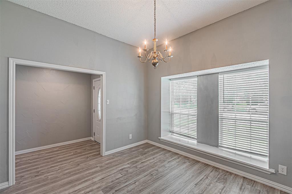 2435 Old Mill Road Dallas, TX 75287 - Photo 6 of 30 a view of an empty room with a window and wooden floor