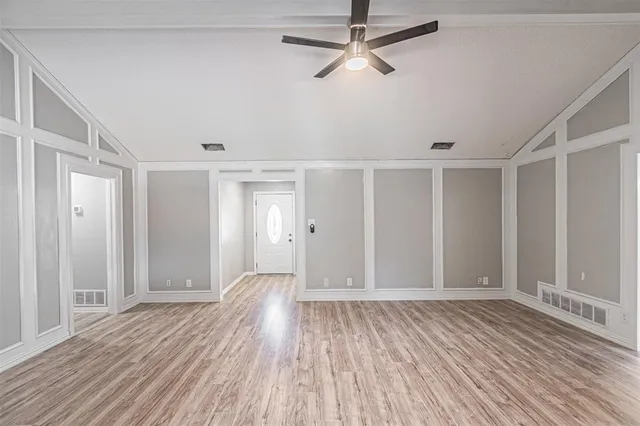 a view of empty room with wooden floor