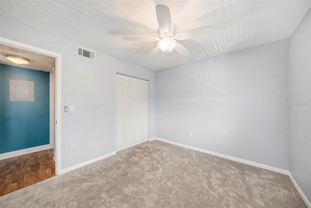 3711 West Iowa Avenue, Unit 214 Tampa, FL 33611 - Photo 18 of 29 an empty room with a chandelier fan and closet