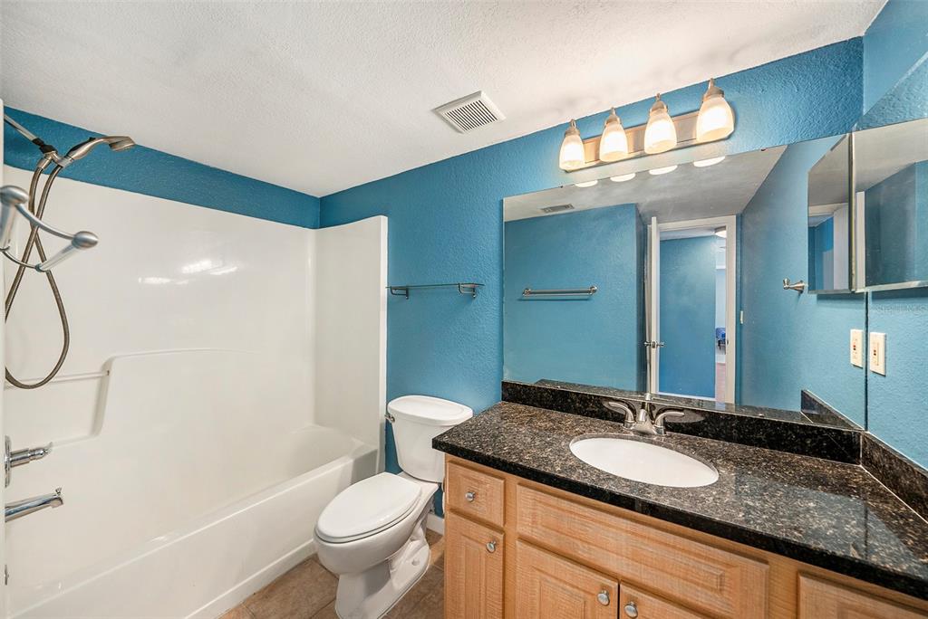 3711 West Iowa Avenue, Unit 214 Tampa, FL 33611 - Photo 20 of 29 a bathroom with a granite countertop sink and a mirror