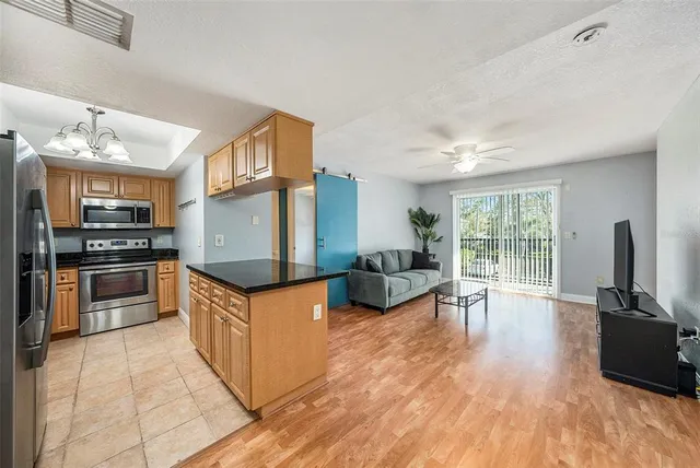 a kitchen with granite countertop a stove top oven a sink dishwasher a dining table and chairs with wooden floor