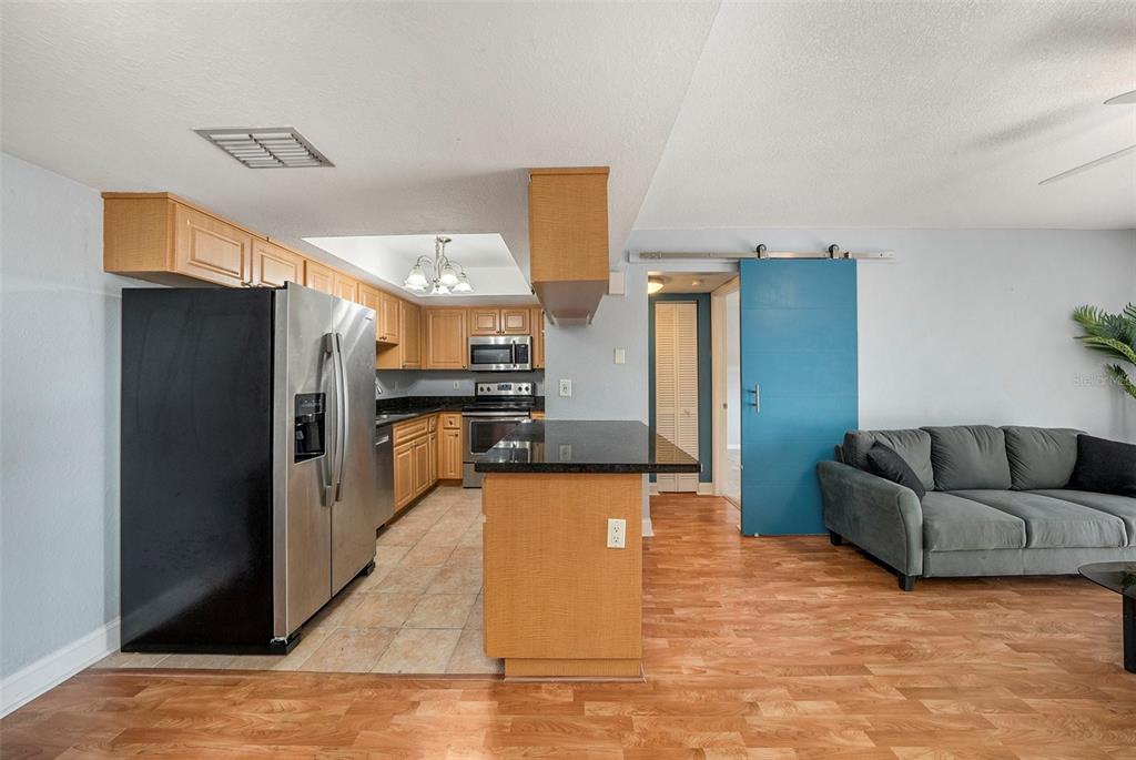 3711 West Iowa Avenue, Unit 214 Tampa, FL 33611 - Photo 4 of 29 a large living room with stainless steel appliances kitchen island granite countertop a refrigerator and a stove top oven