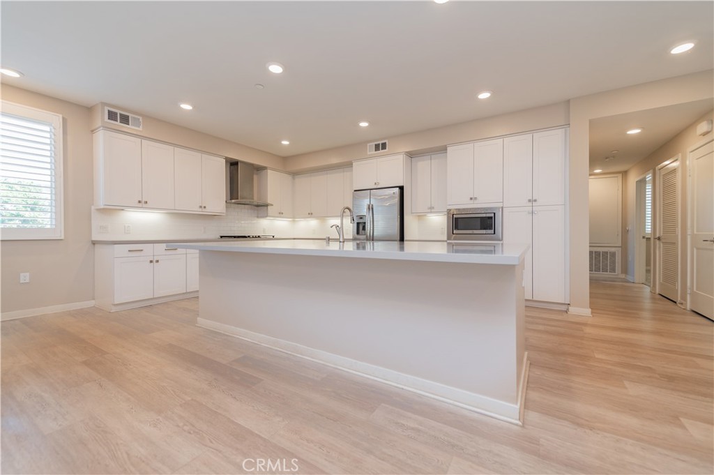 174 Tribeca Irvine, CA 92612 - Photo 10 of 37 a kitchen with stainless steel appliances granite countertop a refrigerator a sink and a stove