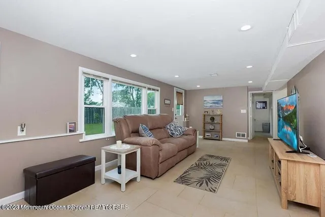 a living room with furniture a flat screen tv and a large window