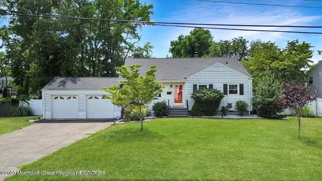 a front view of a house with a yard and a garden