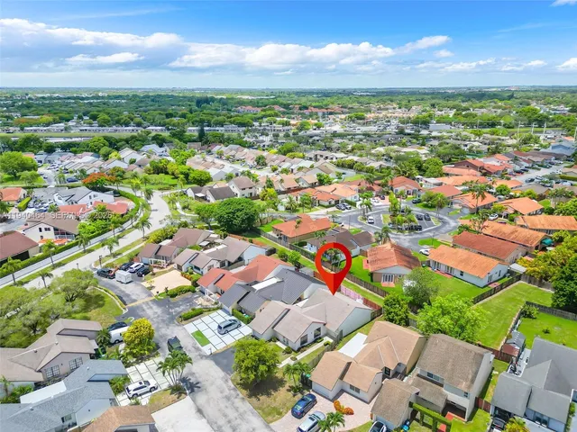 an aerial view of residential houses with outdoor space and ocean view