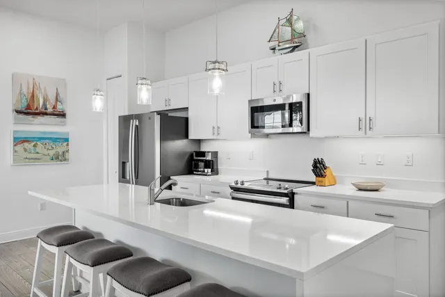 a kitchen with stainless steel appliances granite countertop a sink a stove and a refrigerator