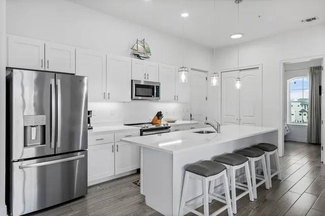 a kitchen with stainless steel appliances a stove a sink and a refrigerator