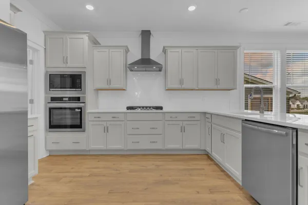 a kitchen with granite countertop white cabinets and stainless steel appliances