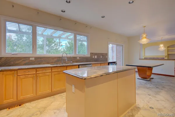 a kitchen with stainless steel appliances granite countertop a sink and a large window