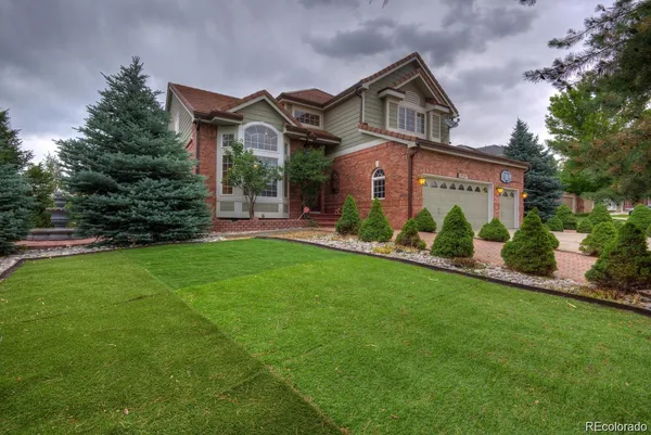 a front view of a house with a yard and green space