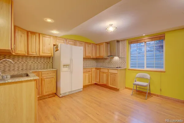 a kitchen with refrigerator cabinets and wooden floor