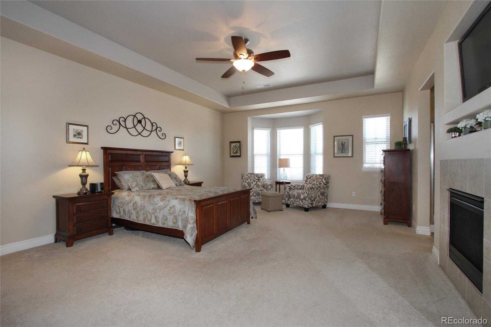 9228 Ridgegate Parkway Lone Tree, CO 80124 - Photo 11 of 32 a spacious bedroom with a bed and a ceiling fan