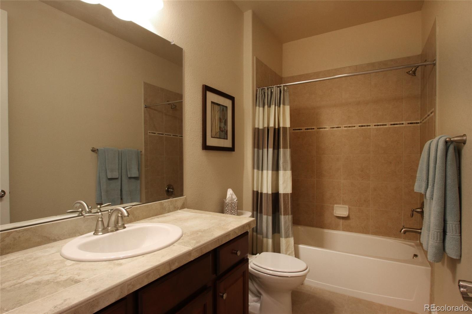 9228 Ridgegate Parkway Lone Tree, CO 80124 - Photo 16 of 32 a bathroom with a granite countertop sink toilet and shower