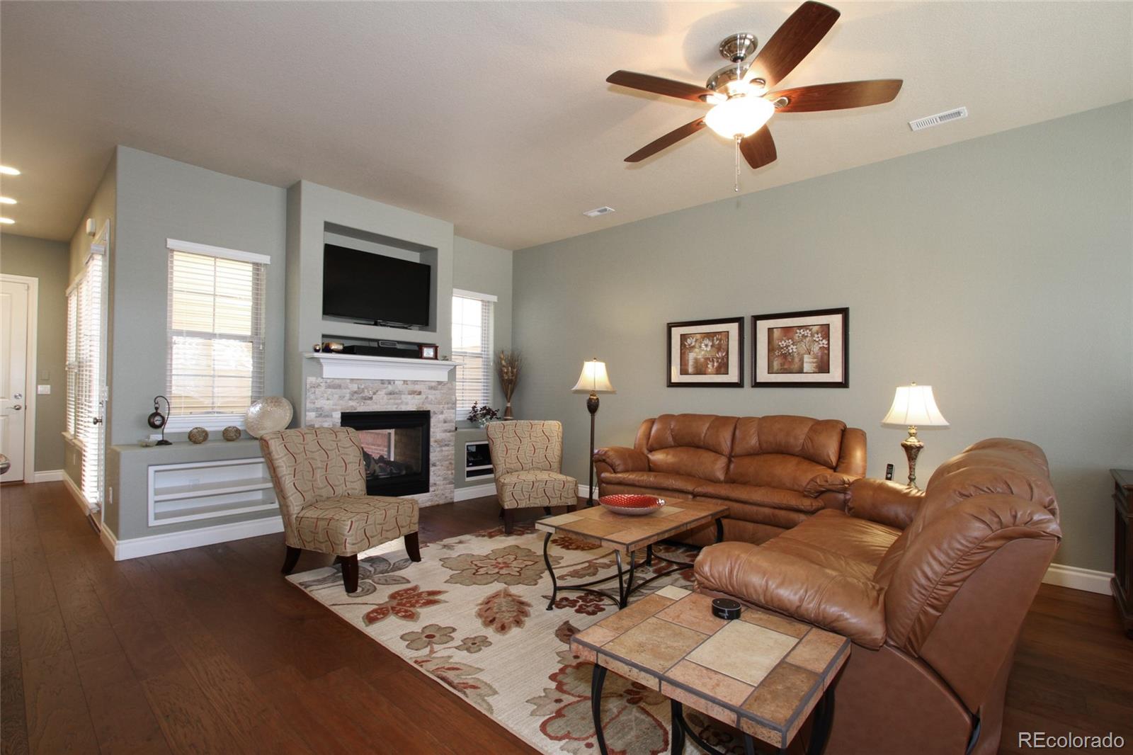 9228 Ridgegate Parkway Lone Tree, CO 80124 - Photo 3 of 32 a living room with furniture a fireplace and a flat screen tv