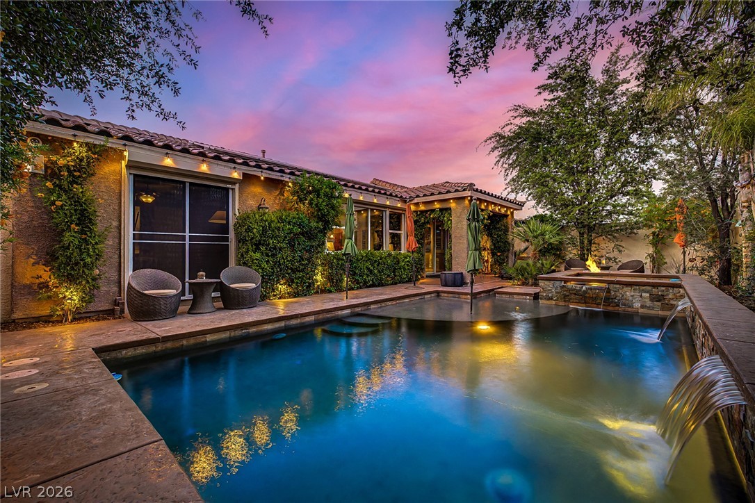7415 Campbell Ranch Avenue Las Vegas, NV 89179 - Photo 45 of 52 An inviting backyard oasis features a glistening pool, complete with water features, a built-in fire pit, and ample space for lounging.
