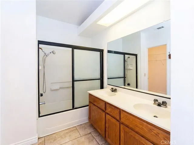 a bathroom with a double vanity sink mirror and shower