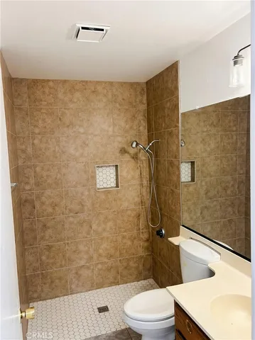 a bathroom with a sink a toilet and shower