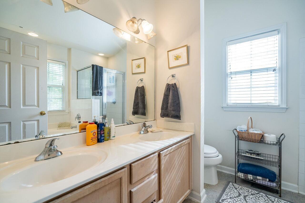 5641 Picnic Rock Lane Raleigh, NC 27613 - Photo 19 of 23 a bathroom with a double vanity sink a mirror and a toilet