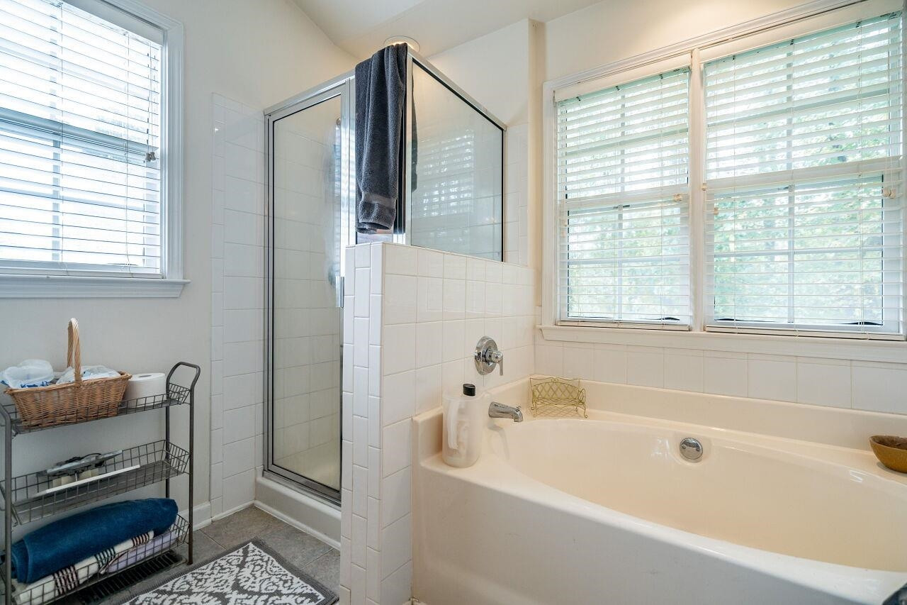 5641 Picnic Rock Lane Raleigh, NC 27613 - Photo 20 of 23 a bathroom with a bathtub a sink and a window