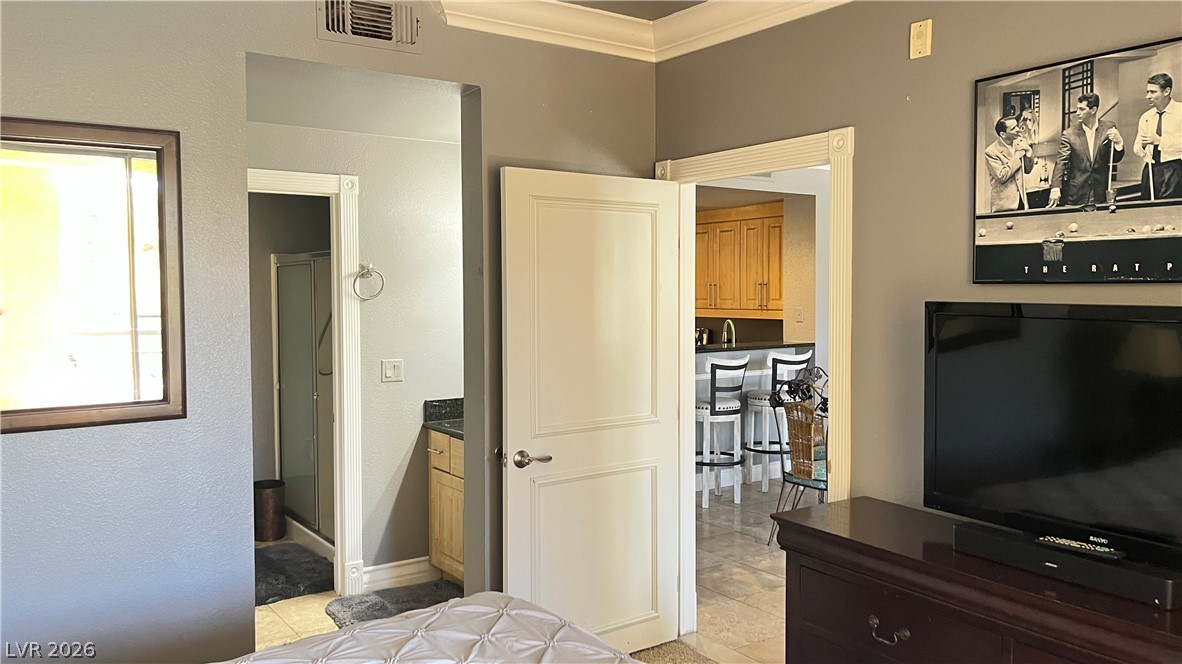 210 East Flamingo Road, Unit 205 Las Vegas, NV 89169 - Photo 13 of 17 A clever layout offers easy access to a private bathroom and an adjoining kitchen from this inviting sleeping area.