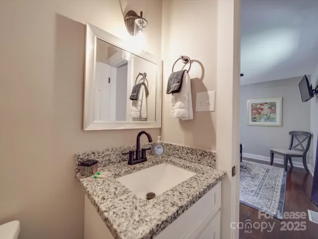 a bathroom with a granite countertop sink a mirror and vanity