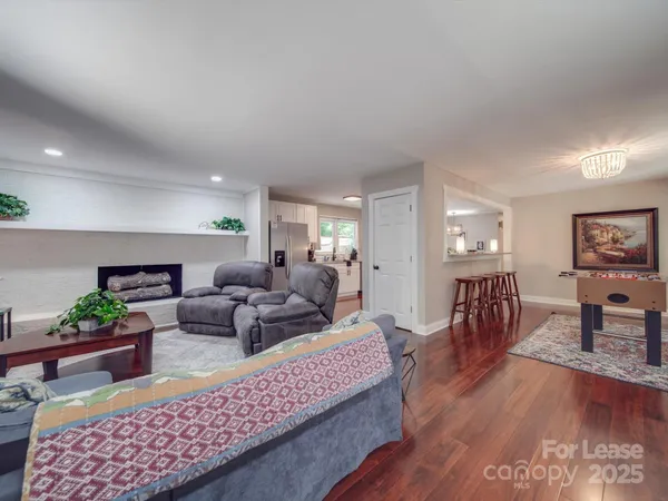 a living room with fireplace furniture and wooden floor