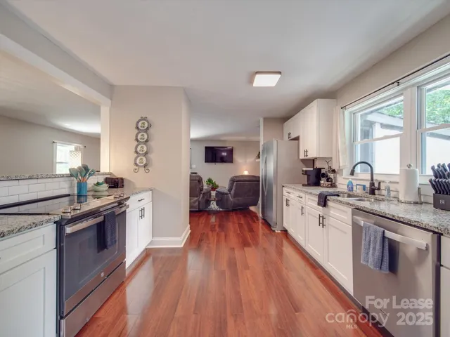a large kitchen with stainless steel appliances granite countertop a stove and cabinets