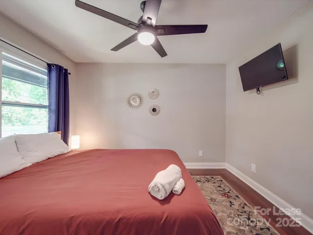 a bedroom with a bed and a flat screen tv