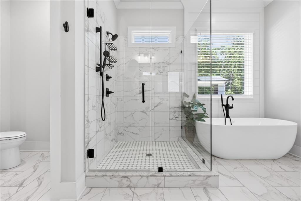 3528 North Bogan Road Buford, GA 30519 - Photo 28 of 79 a bathroom with a tub a toilet and a shower
