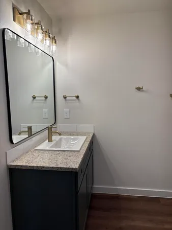 a bathroom with a granite countertop sink and a mirror