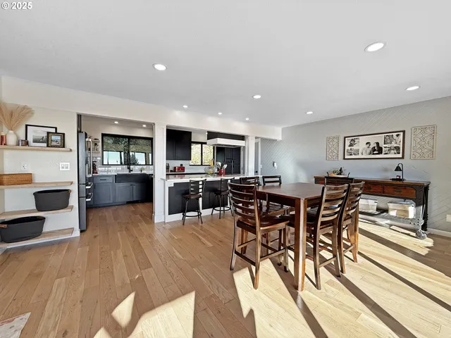a open kitchen with stainless steel appliances kitchen island granite countertop a table and chairs in it