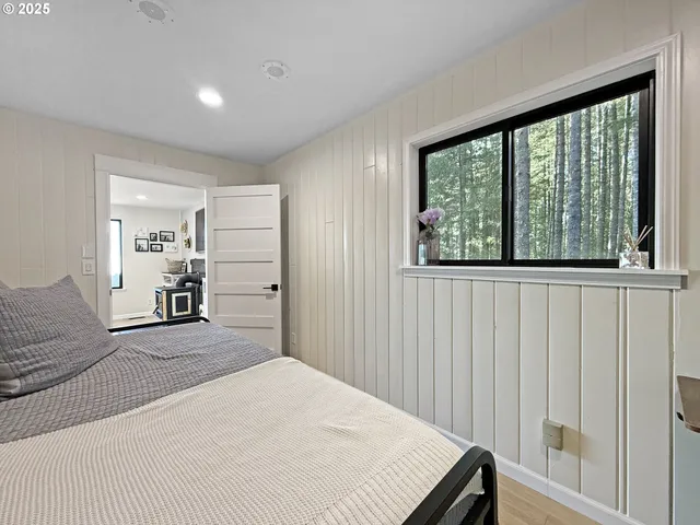 a bedroom with a bed and a large window