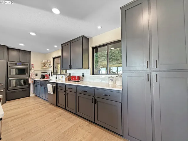 a kitchen with stainless steel appliances granite countertop a refrigerator and a sink