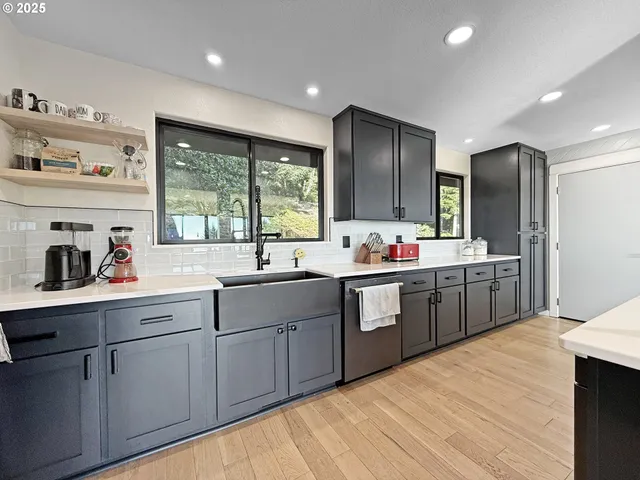 a large kitchen with kitchen island granite countertop a sink stainless steel appliances and cabinets