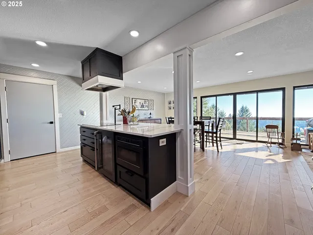 a kitchen with a wooden floor and a large window