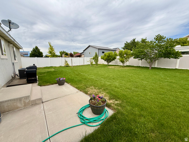 1353 360 West Payson, UT 84651 - Photo 15 of 16 Expansive backyard featuring a manicured lawn, a large concrete patio, and a privacy fence