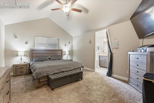 a bedroom with a bed and a flat tv screen on a dresser