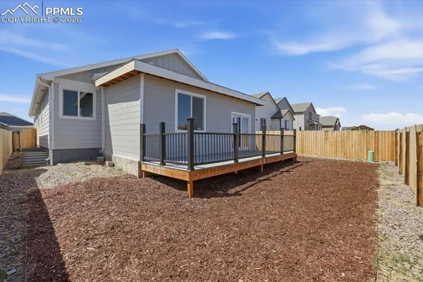a view of a house with a yard and wooden fence